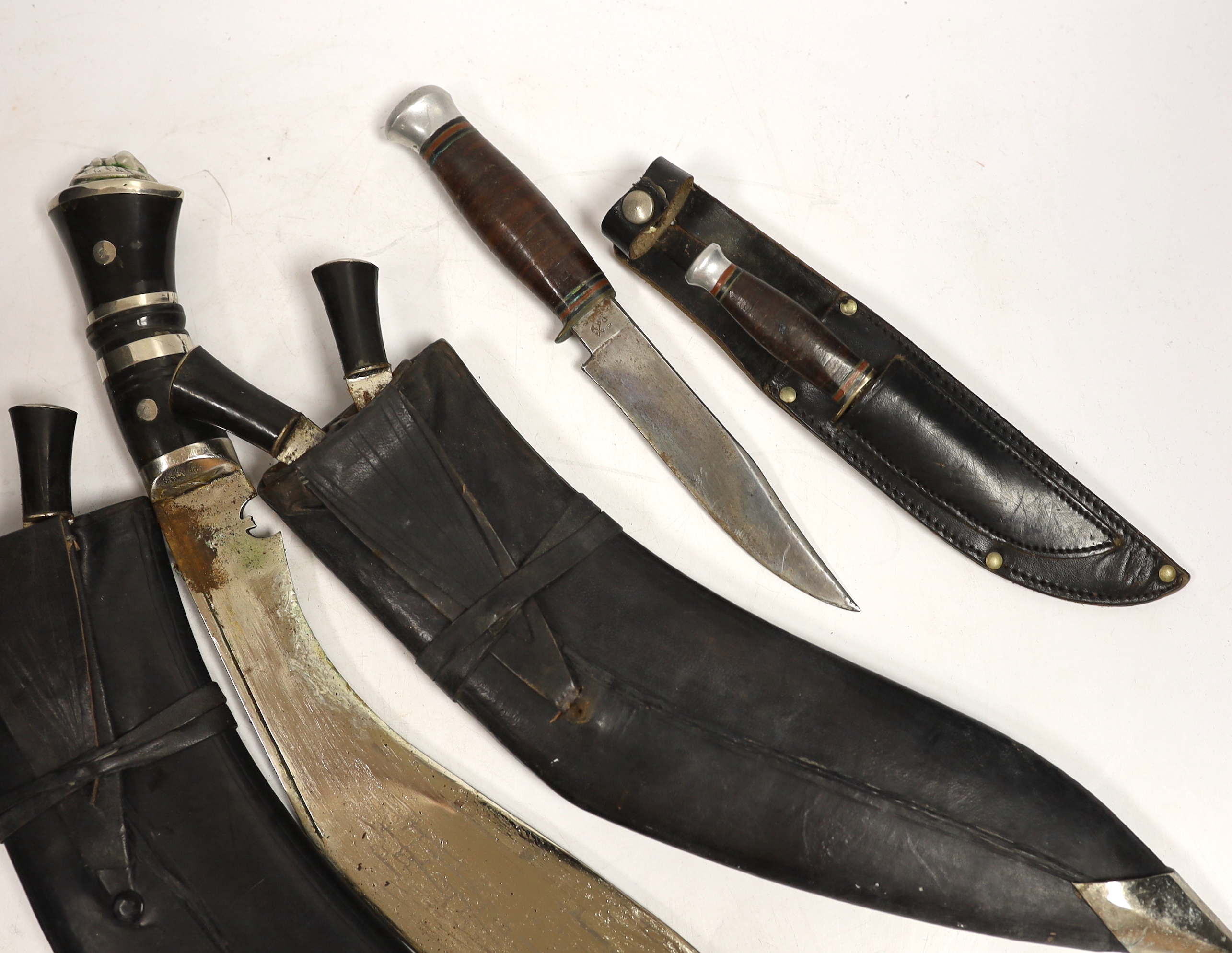 Two large kukris and a smaller similar kukri